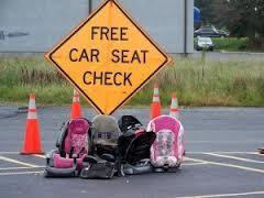 Free Car Seat Check sign with car seats sitting on the road