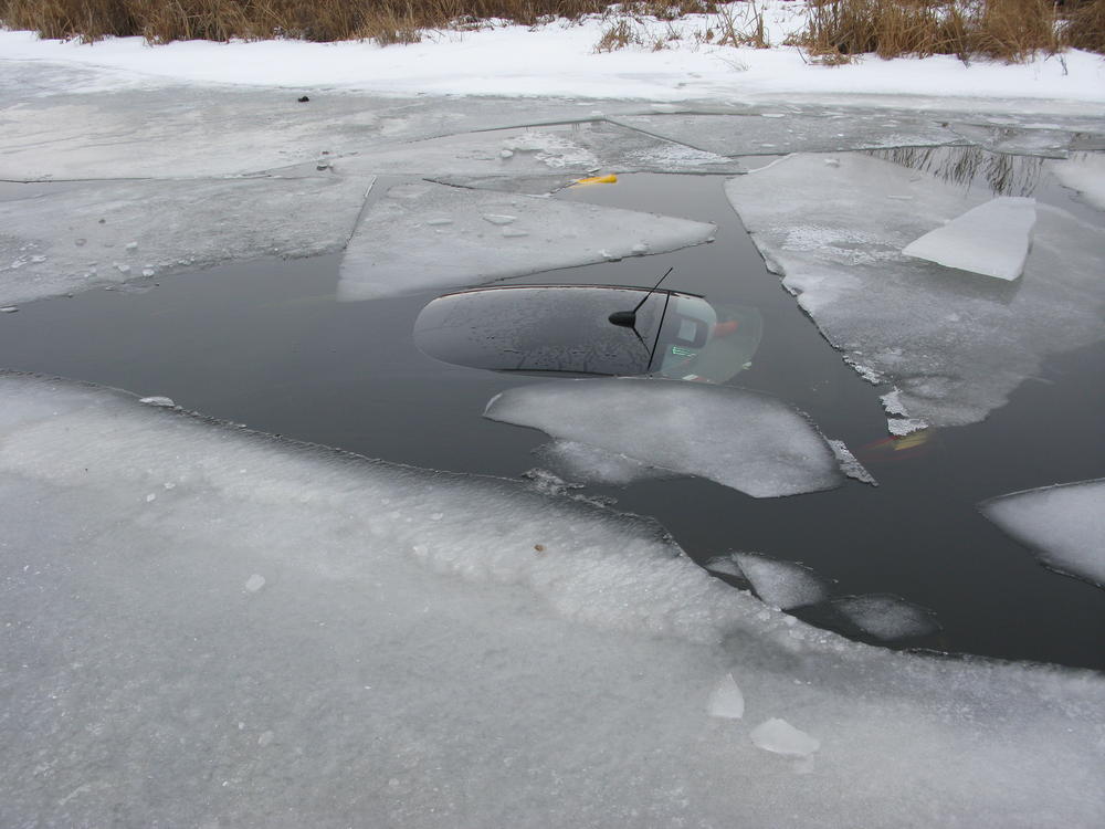 Vehicle submerged in water under ice