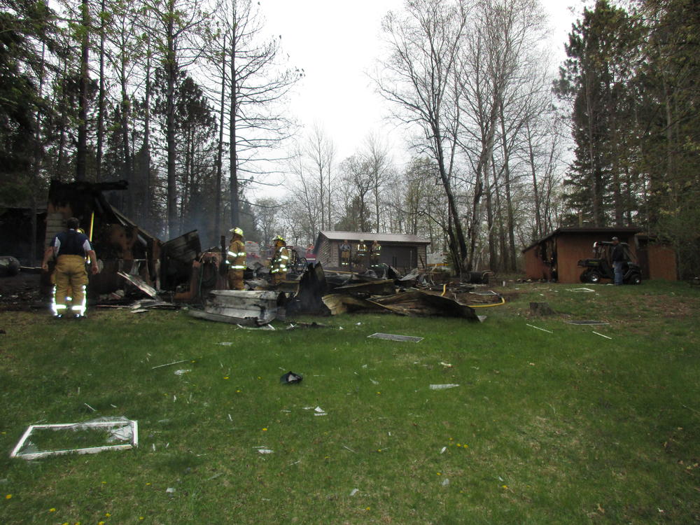 firefighters at the scene of fire damage to home and property