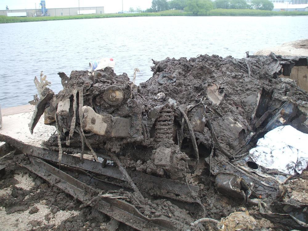 remnants of vehicle covered in mud and rust